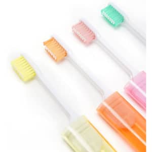 A set of travel folding toothbrushes in pastel colours, each with a protective case, arranged in a row.