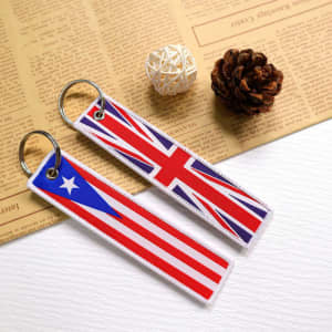 Custom woven label keychains featuring a red, white, and blue design, with a logo on metal rings.