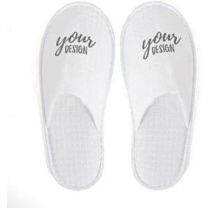 A pair of white disposable hotel slippers with a textured surface and a logo printed on them.