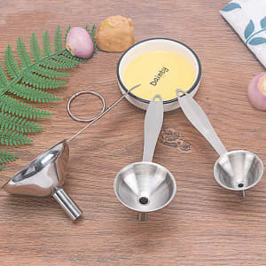 A stainless steel funnel set featuring two sizes and a long handle, accompanied by a measuring spoon and a bowl.