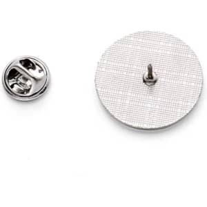 A circular metal pin badge with a textured surface and a silver clasp on the side.