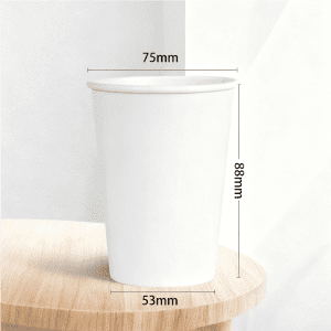 A disposable kraft paper cup, sized 9 oz, in white, with dimensions marked on the side, placed on a wooden surface.