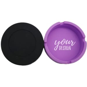 A round, portable silicone ashtray in black and purple, featuring a space for custom design. Includes branding.
