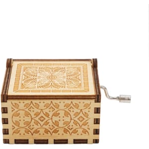 A wooden music box with intricate carvings, featuring a small metal handle on the side.