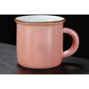 A pink ceramic campfire mug with a white interior and a gold rim, featuring a handle for easy gripping.