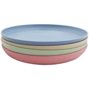A set of four unbreakable plates in blue, green, pink, and beige, stacked neatly with a smooth surface.