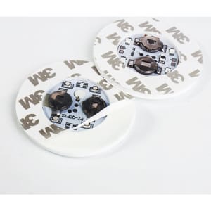 Two circular LED light coasters in white, featuring a 3M adhesive backing and interior components.