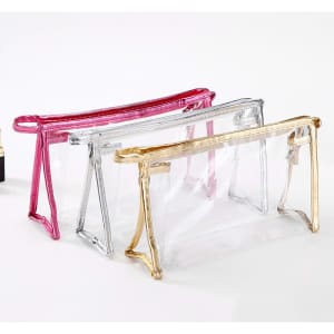 A clear PVC travel zippered cosmetic bag in pink, silver, and gold, featuring a transparent design and a zip closure.