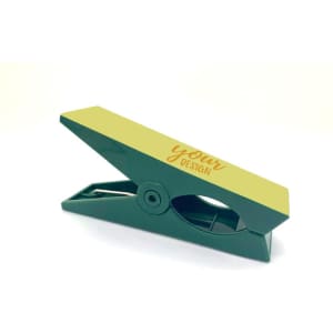 A green windproof cloth clip with a yellow top for personalised designs. Features a branding logo.