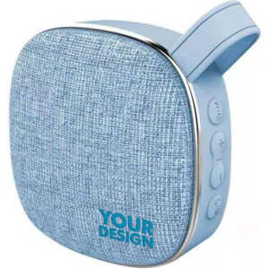 A small fabric wireless speaker in light blue with a textured finish and a branding logo on the front.