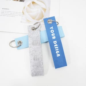 A set of custom felt key chains in grey and blue, featuring a design and metal rings for attachment.