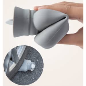 A grey silicone hot water bottle featuring a knitted sleeve, held in a hand with a close-up showing the spout.
