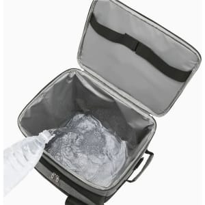 A drink bottle pours water into an insulated wheeled cooler bag, featuring a grey interior. The bag has a logo.