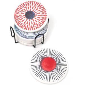 A set of ceramic coasters with vibrant red and blue designs, displayed in a black metal holder.
