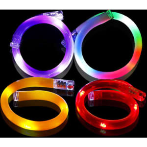 Four LED luminous bracelets in purple, yellow, red, and multicoloured, each emitting vibrant light.