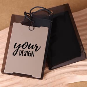 A custom PVC hang tag in light brown with a black backing and a black string for attachment.