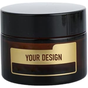 A cosmetic packaging container jar with a black lid and dark amber body, featuring a blank label for custom designs.