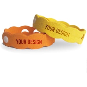 Two mosquito repellent bracelets in orange and yellow, featuring a design area, with a rounded, textured shape.
