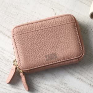 A portable pink PU key holder wallet with a textured finish and a zip closure, featuring a logo.