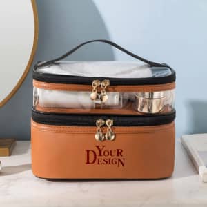 A double-layer toiletry bag in tan and black with transparent sections, containing towels and containers, features a logo.