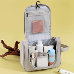A grey portable hanging travel toiletry bag with various bottles and compartments inside.