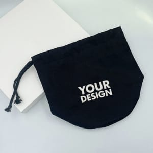 A black drawstring toiletry bag with a design area and a matching drawstring. It has a solid form and simple style.