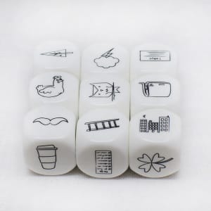 A set of nine white acrylic dice featuring various black icons, including a chicken, cloud, and buildings.