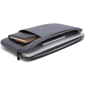 A grey 15.6-inch laptop sleeve case with a notebook and a laptop inside. It features a simple design and has a logo.