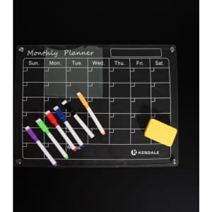 A magnetic dry erase calendar whiteboard set with a black surface, colourful markers, and an eraser. It features a branding logo.