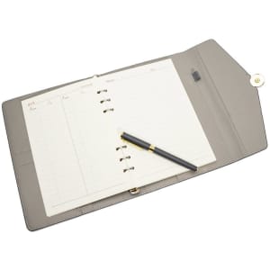 A spiral notebook with a grey cover, featuring blank pages and a black pen resting on top.