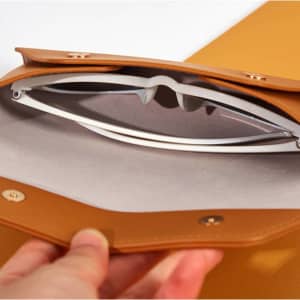 A PVC leather protective case in brown, featuring a pair of white glasses inside. The interior is lined with soft material.