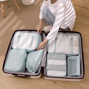A light blue luggage storage travel kit shown inside an open suitcase, featuring various bags of different sizes.