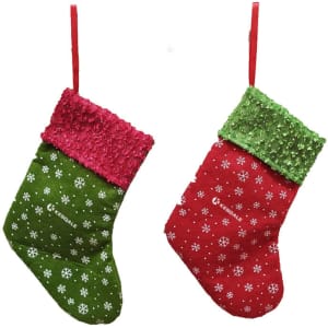 A Christmas stocking-shaped gift bag in green and red with sequined trim and snowflake patterns, featuring a logo.