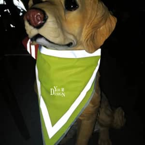 A reflective pet triangle scarf in bright green, displayed on a dog model, featuring a logo.