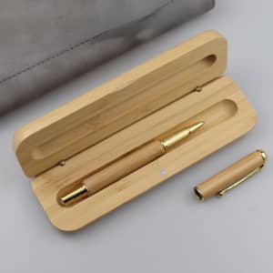 A bamboo fountain pen with a gold trim, nestled in a wooden gift box. The set has a natural finish.