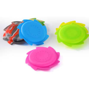 Four brightly coloured flying discs in pink, blue, green, and patterned designs. Each disc features a circular shape with slots.