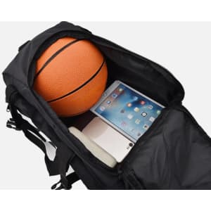 A black duffel bag with zippered pockets, containing a basketball and a tablet.
