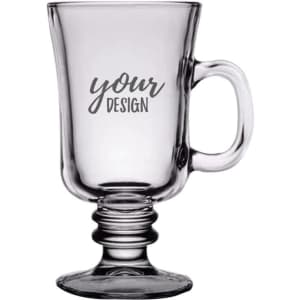 A transparent glass Irish coffee mug with a handle and decorative foot, featuring a placeholder for a design.