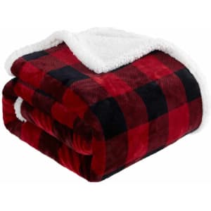 A folded double layer flannel blanket in red and black check pattern with a soft white fleece lining.