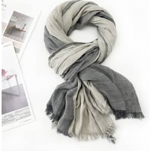 A soft shawl wrap scarf in grey and light grey, featuring tassels at the ends and arranged elegantly.