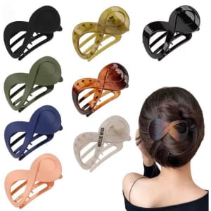 A collection of custom hair clips in various colours, including black, brown, green, and peach, displayed on a model.