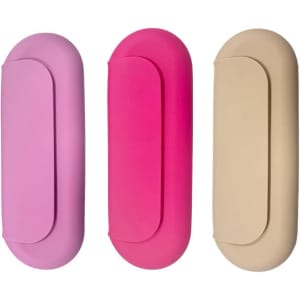 Three silicone makeup brush holders in pink, fuchsia, and beige, featuring smooth, rounded designs.