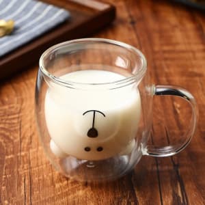A double wall glass coffee cup in clear glass featuring a bear design at the bottom.