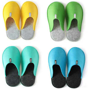 Four pairs of custom non-slip felt slippers in yellow, green, turquoise, and aqua, each featuring a logo.