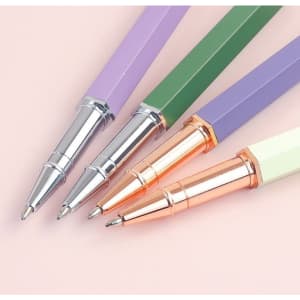 A collection of four personalised ballpoint pens in purple, green, and cream with silver and rose gold accents.