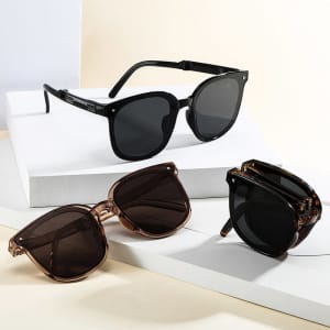 Three pairs of polarized folding sunglasses in black and brown hues displayed on a white surface.