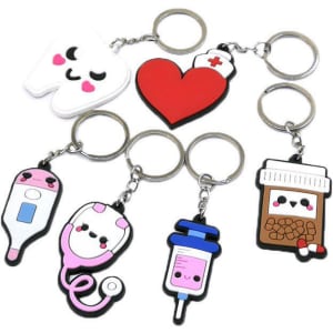 A collection of colourful PVC rubber keyrings featuring a tooth, heart, thermometer, stethoscope, syringe, and medication bottle.