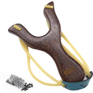 A wooden slingshot with a dark brown finish, yellow bands, and a package of metallic balls beside it.