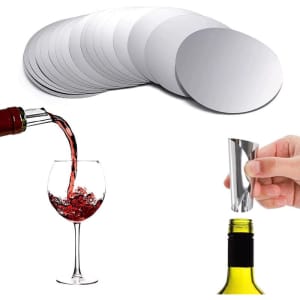 A set of circular silver wine pourer discs, alongside a glass of red wine and a pouring spout on a bottle.