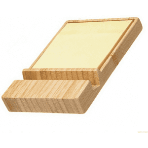 A bamboo sticky note dispenser with a phone holder, featuring a pale yellow sticky note pad.